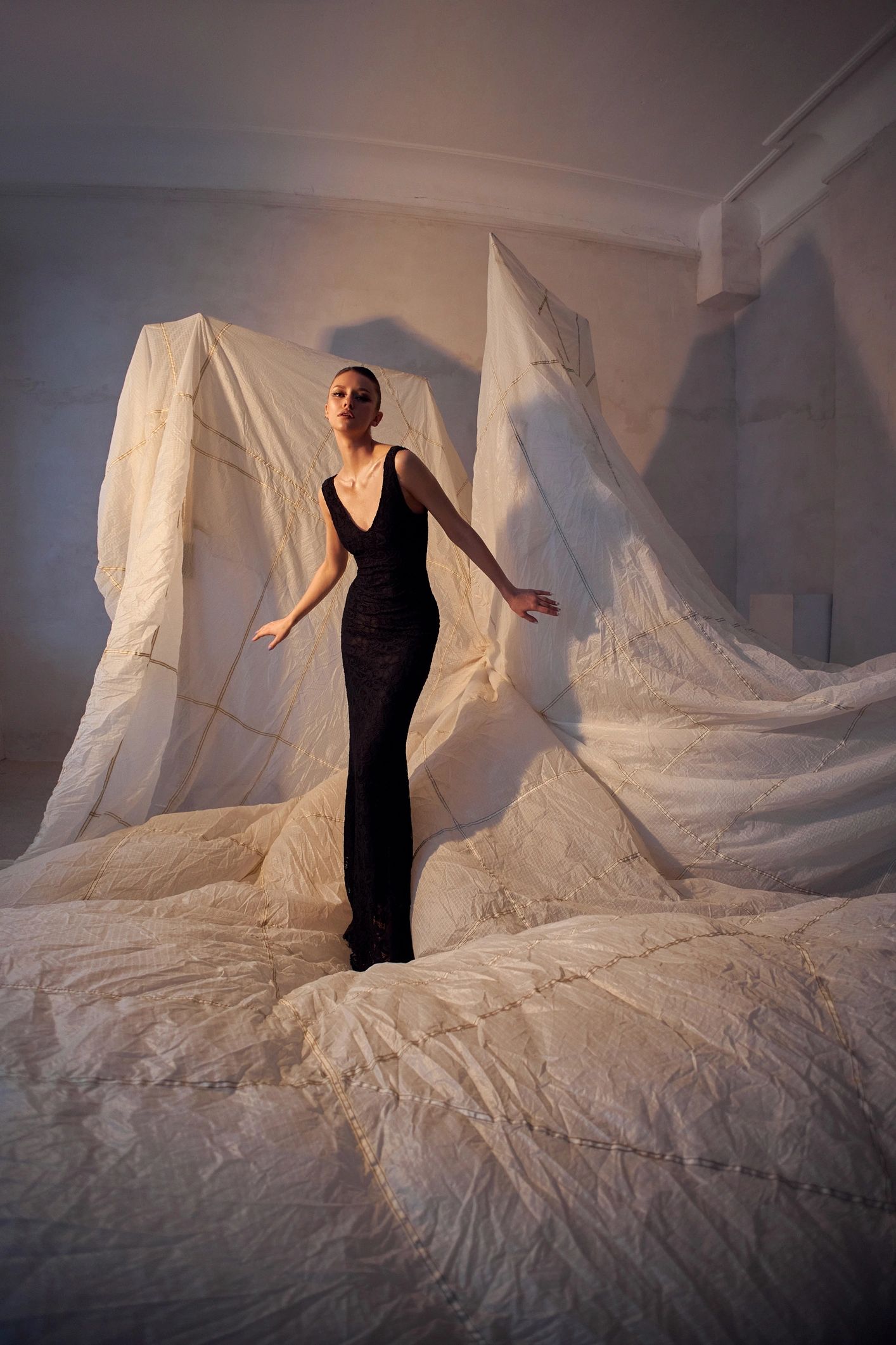 Creative fashion portrait with dramatic fabric backdrop